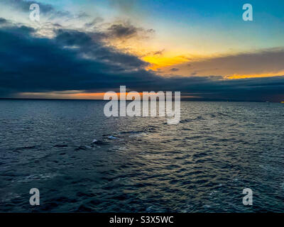 Sun setting over the Balearic sea in the Mediterranean with Barcelona in view Stock Photo