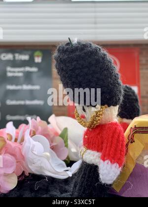 Ipswich, Suffolk, UK - 19 September 2022 : Mourning the death of Queen Elizabeth II. Crochet guardsman with head bowed on a Royal Mail post box. Stock Photo
