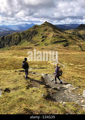 Walkers on the path of the Tarmachan ridge, with a view of the ...