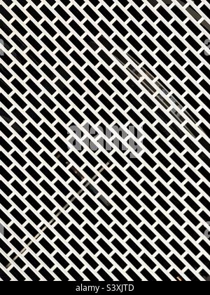 Pattern formed by the metal security grille on the entrance to a shop. No people. Stock Photo