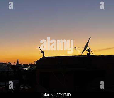 Satellite dishes in marrakech at sunset with an orange sky on the background Stock Photo