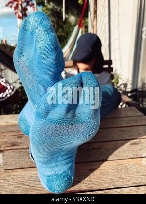 Close up of a boy‘s Feet on a Table with dirty socks Stock Photo