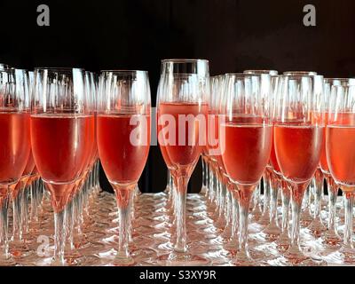 Rows of flute glasses filled with pink champagne. No people. Stock Photo