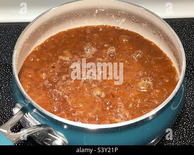 Home made brown gravy, the best around as far as our family goes, simmering on the stove on Thanksgiving Day in Utah, USA. Stock Photo