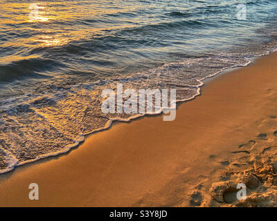 Sea breaking on beach at sunset. Lardos bay at Kefkos island of Rhodes, Greece Stock Photo