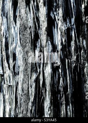 Full frame textured background of hard granite rock with marble worn and weathered from coastal erosion with copy space Stock Photo