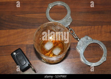 Handcuffs, whisky and car keys Stock Photo