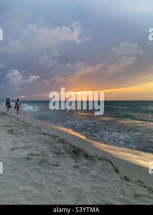 Two women walking along varadero beach. Varadero, Cuba Stock Photo