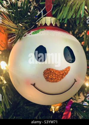Snowman face Christmas ornament hanging on Christmas tree Stock Photo