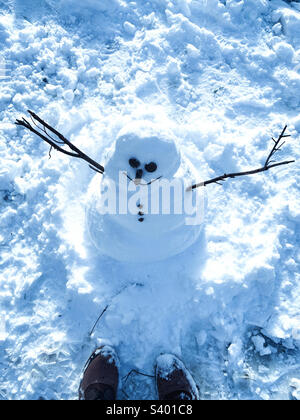 A person standing in front of snow man 2022 Stock Photo