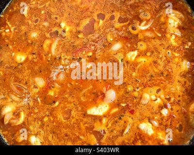 Hearty vegetable soup with corn and pumpkin simmering in a pot Stock Photo