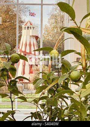 Psidium Guajava (Guava Plant) with a helter skelter fairground attraction behind. The Royal Botanic Gardens at Kew, London Stock Photo