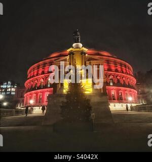 View of the red illuminated Royal Albert Hall and Christmas tree at night Stock Photo