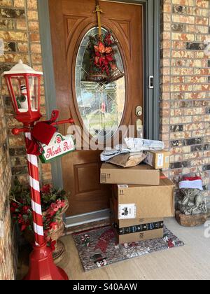 Amazon packages at the front door with Christmas decorations on the porch Stock Photo