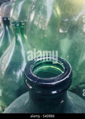 Rows of Vintage Large Green Carboy Demijohn Glass Wine Bottles. Stock Photo