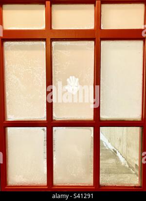 Frosted winter windows with handprint. Stock Photo