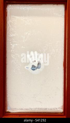 Handprint on a frosted window. Stock Photo