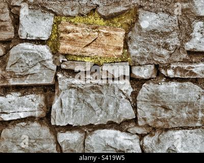 A rough hewn wall of stone with a grunge effect added. Stock Photo