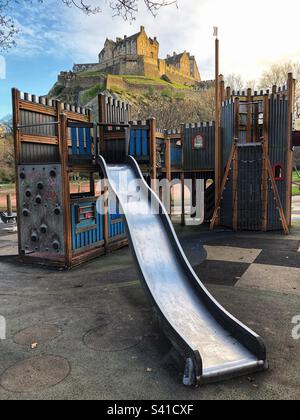 Kids playground chute in Princes Street Gardens with Edinburgh Castle as a backdrop Stock Photo