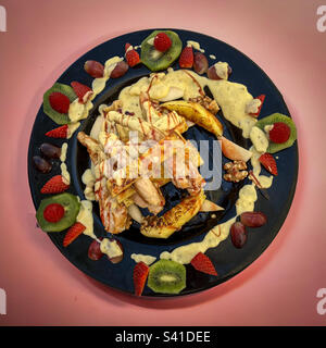Chicken Hawaï on a black plate Stock Photo
