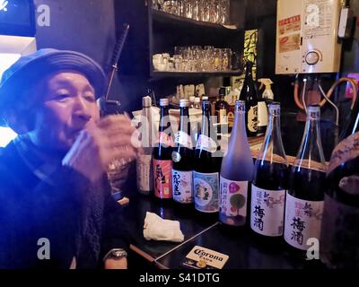 Drinking in a small bar at he Golden Gai pubs in Kabukicho, Shinjuku, Tokyo, Japan. Stock Photo
