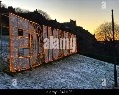 Wintry snow at the 2022 Edinburgh Christmas neon sign at the Mound with the castle silhouetted behind, Edinburgh Scotland Stock Photo