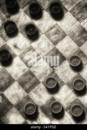 Top down nostalgic image of an old weathered checkerboard in sepia tone Stock Photo