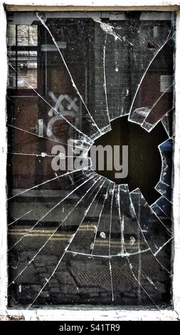 Broken window pane in alleyway Stock Photo