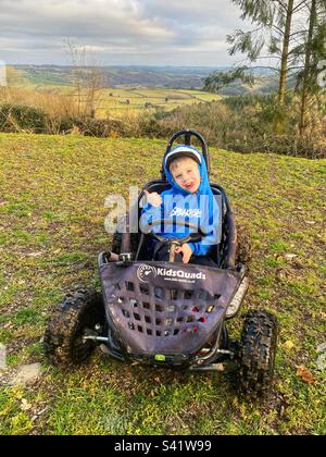 Six year old boy in an electric go-kart. North Devon, England, United Kingdom. Stock Photo