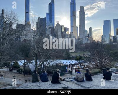 Sunset behind the Essex House and New York skyline. View over Wollman Rink in Central Park, NY, USA. February 20, 2023. Stock Photo