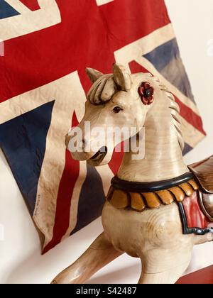Rocking horse in front of vintage flag Stock Photo