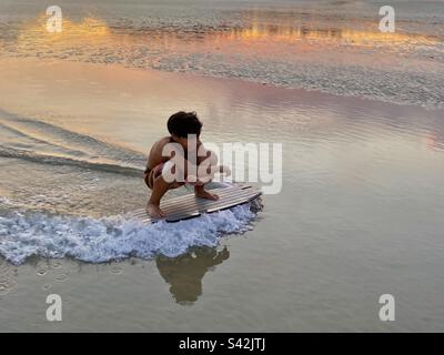 An 11 year old boy practices and skim boarding. – Krabi Thailand Stock Photo