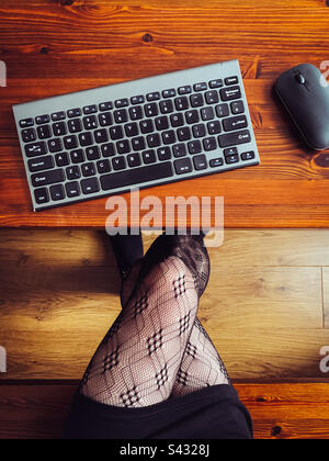 Top view of a woman working at desk with a keyboard and mouse Stock Photo