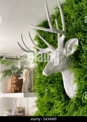 Faux deer head decoration on a green wall Stock Photo