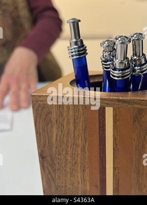 Fancy blue ink pens in handmade wooden pencil holder. Includes print space. Stock Photo