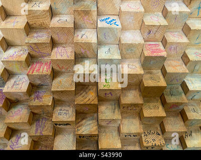 A wooden block wall with added graffiti. Stock Photo