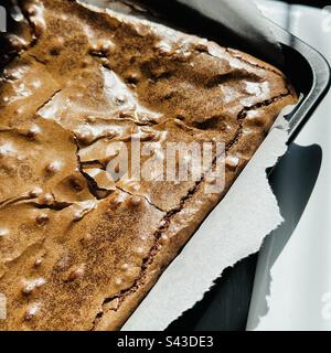 Chocolate brownie cooking in a baking tin in the sunshine Stock Photo
