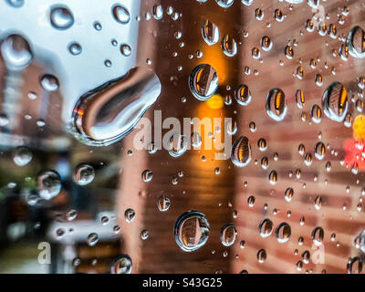 Raindrops on glass window in city Stock Photo