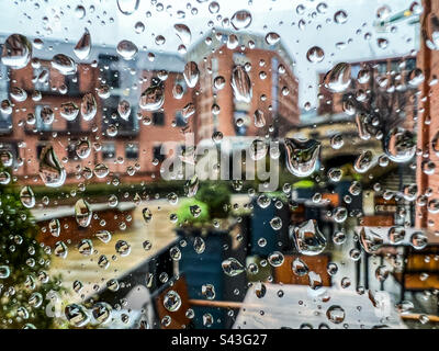 Raindrops on glass window in city Stock Photo