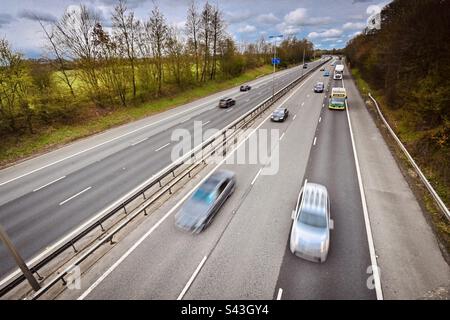 Fast moving motorway traffic passing under a bridge in the UK Stock Photo