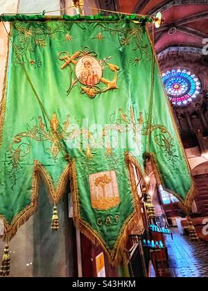 Green flag or pennant with anchor in the Church of St Bartholomew in Soller. The village is connected to the port and fishing. Rose window in background. Stock Photo