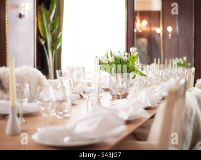 A long banquet table is set for a meal Stock Photo