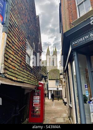 St. Mary’s in Ashford from a small alley, signature red phone booth Stock Photo