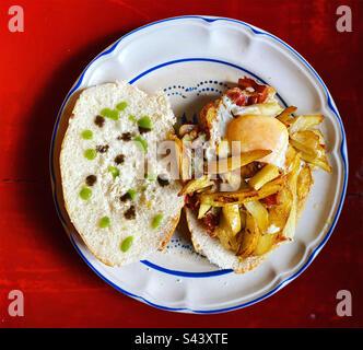 Sandwich made of fried potatoes, a fried egg, bacon and Spanish serrano ham with habanero hot chilli peppers sauce in Queretaro, Mexico Stock Photo