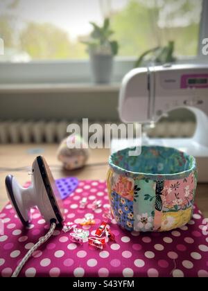 Patchwork textile Box with small iron and clips and sewing machine Stock Photo
