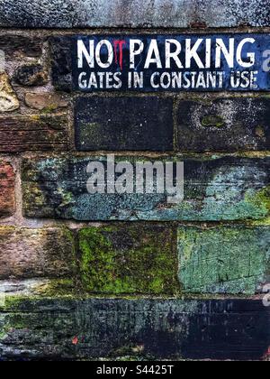No parking sign on an old damp stone wall Stock Photo
