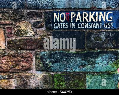 No parking sign on an old damp stone wall Stock Photo
