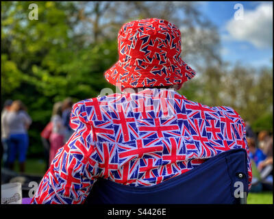 A patriotic British person wears a jacket & hat adorned with images of the Union Jack flag in May 2023 to celebration the Coronation of King Charles III and Queen Camila. Photo ©️ COLIN HOSKINS. Stock Photo