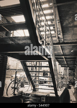 View from the underneath of an industrial metal staircase at a workplace in London Stock Photo