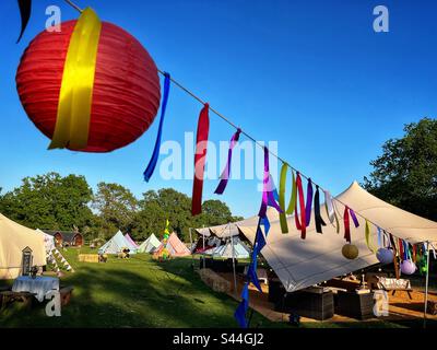 A Chinese lantern is seen hanging with bunting at a campsite set up for a party in Hampshire. Stock Photo